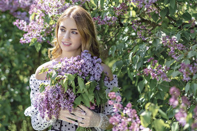 Portrait of a smiling young girl in blooming lilac trees. summer time,vacation.