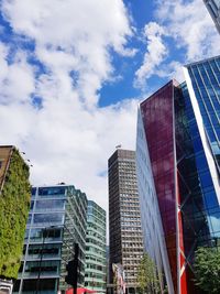 Low angle view of modern buildings against blue sky