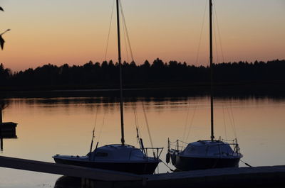 Boats sailing in lake during sunset