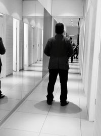 Rear view of men standing in corridor of building