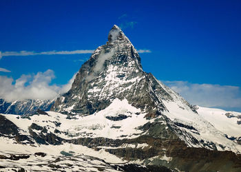 Scenic view of snowcapped mountains against clear blue sky