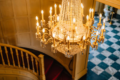 Low angle view of illuminated chandelier hanging on ceiling