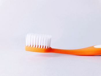 Close-up of orange toothbrush against gray background