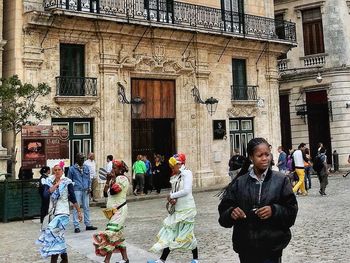 People standing on street against buildings in city