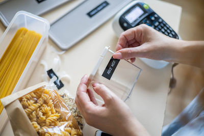 Cropped hands of woman labeling container