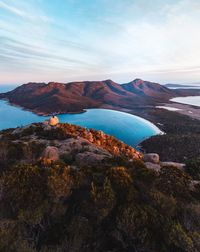 Scenic view of sea and mountains against sky