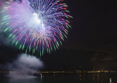 Firework display over sea at night