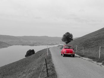 Car on road by mountain against sky