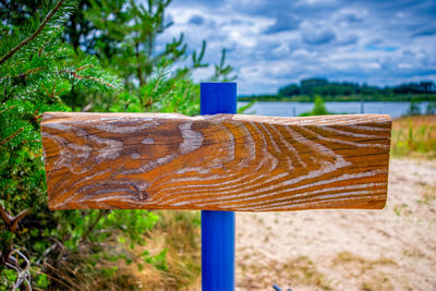 Close-up of wooden post on field against trees