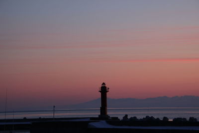 Silhouette of lighthouse against sky during sunset