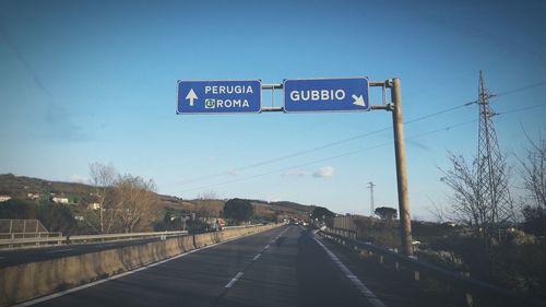 Road sign against blue sky
