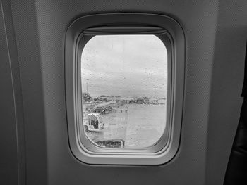 View of airport from airplane window on a rainy day, before taking off