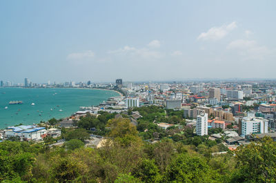 Cityscape by sea against sky