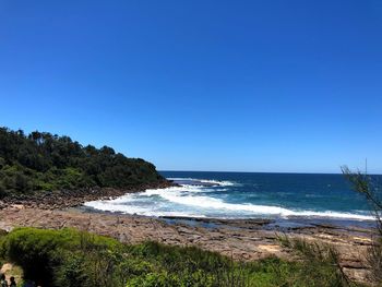 Scenic view of sea against clear blue sky