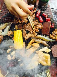 Close-up of man preparing food on barbecue grill