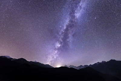 Scenic view of silhouette mountains against star field at night