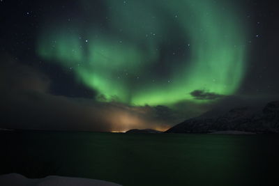 Scenic view of lake against sky at night with northern lights 