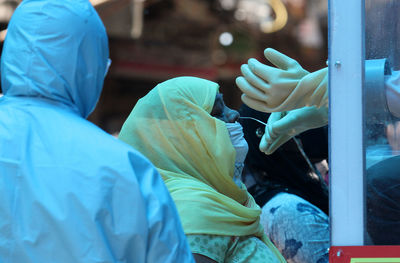 Side view of people holding umbrella