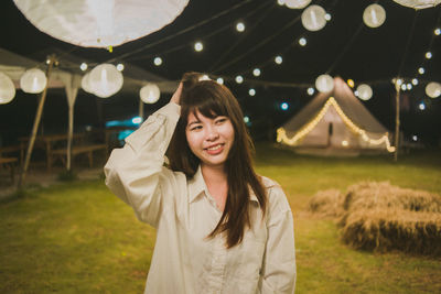 Portrait of beautiful young woman standing in field