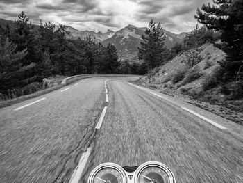 Rider's view on a motorcycle approaching a curve in the mountains after a pass