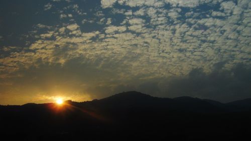 Scenic view of silhouette mountains against sky at sunset