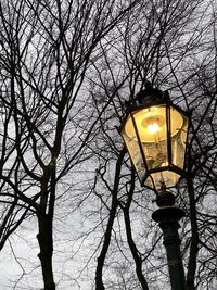 Low angle view of illuminated street light against sky