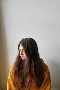 Portrait of a young woman against wall