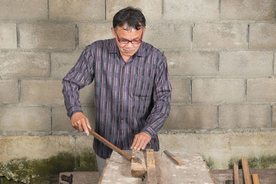 Man working at table against wall