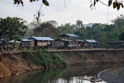 Houses by river against sky