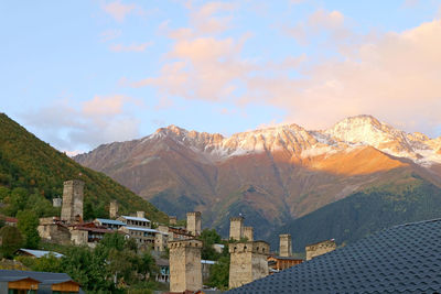 Buildings in town against cloudy sky