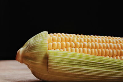 Close-up of yellow cake on table against black background