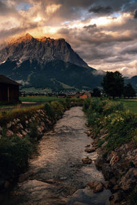 Footpath leading towards mountains against sky