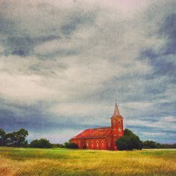 Built structure on field against cloudy sky