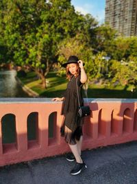 Portrait of young woman standing against built structure