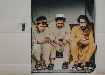 Men using smart phones while sitting in vehicle