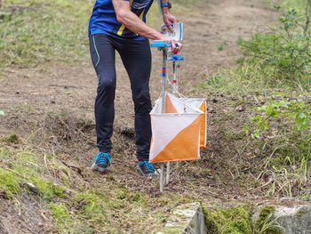 Person racing to an orienteering check point, put the finger chip into digital check box. 