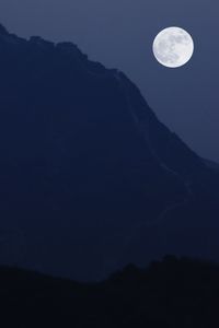 Scenic view of moon and mountains against sky at night