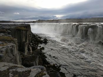 Scenic view of waterfall against sky