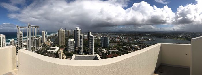 Panoramic view of buildings against cloudy sky