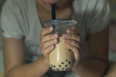 Midsection of woman drinking glass