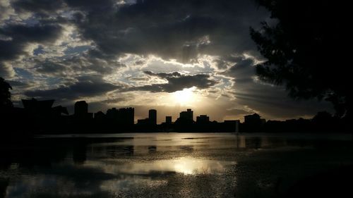 Sunset over calm river with buildings in background