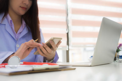 Midsection of woman using mobile phone