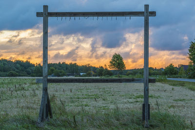 Fence on countryside landscape at sunset