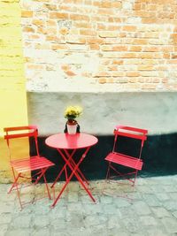 Empty chairs and table against wall in building