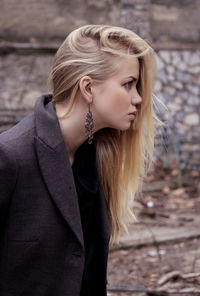 Young woman looking away by wall