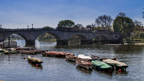 Boats in river with bridge in background