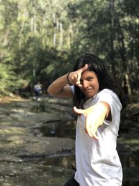 Full length of woman standing by tree in forest