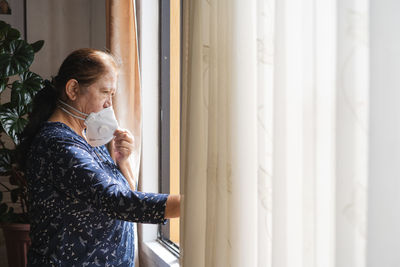 Woman looking through window