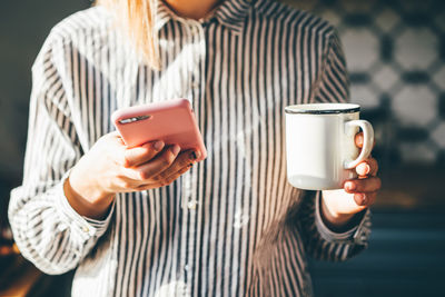 Midsection of woman using mobile phone