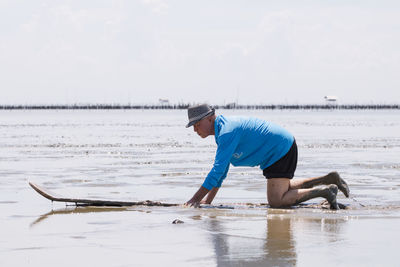 Side view of man on beach against sky